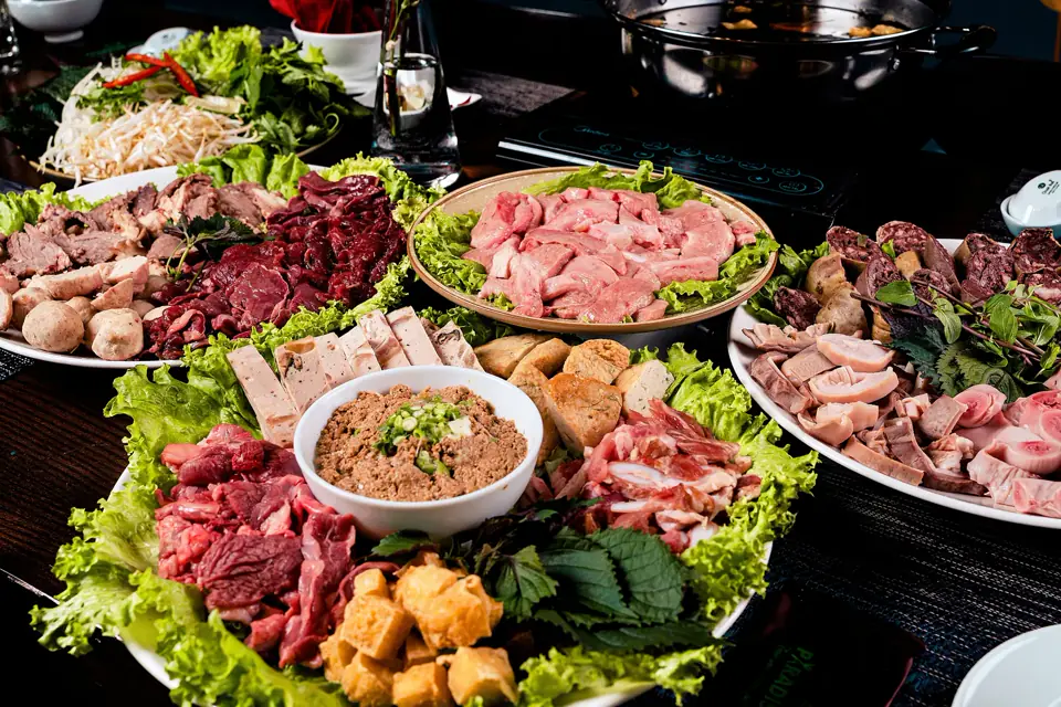 A generous Sichuan hotpot table with meats and vegetables